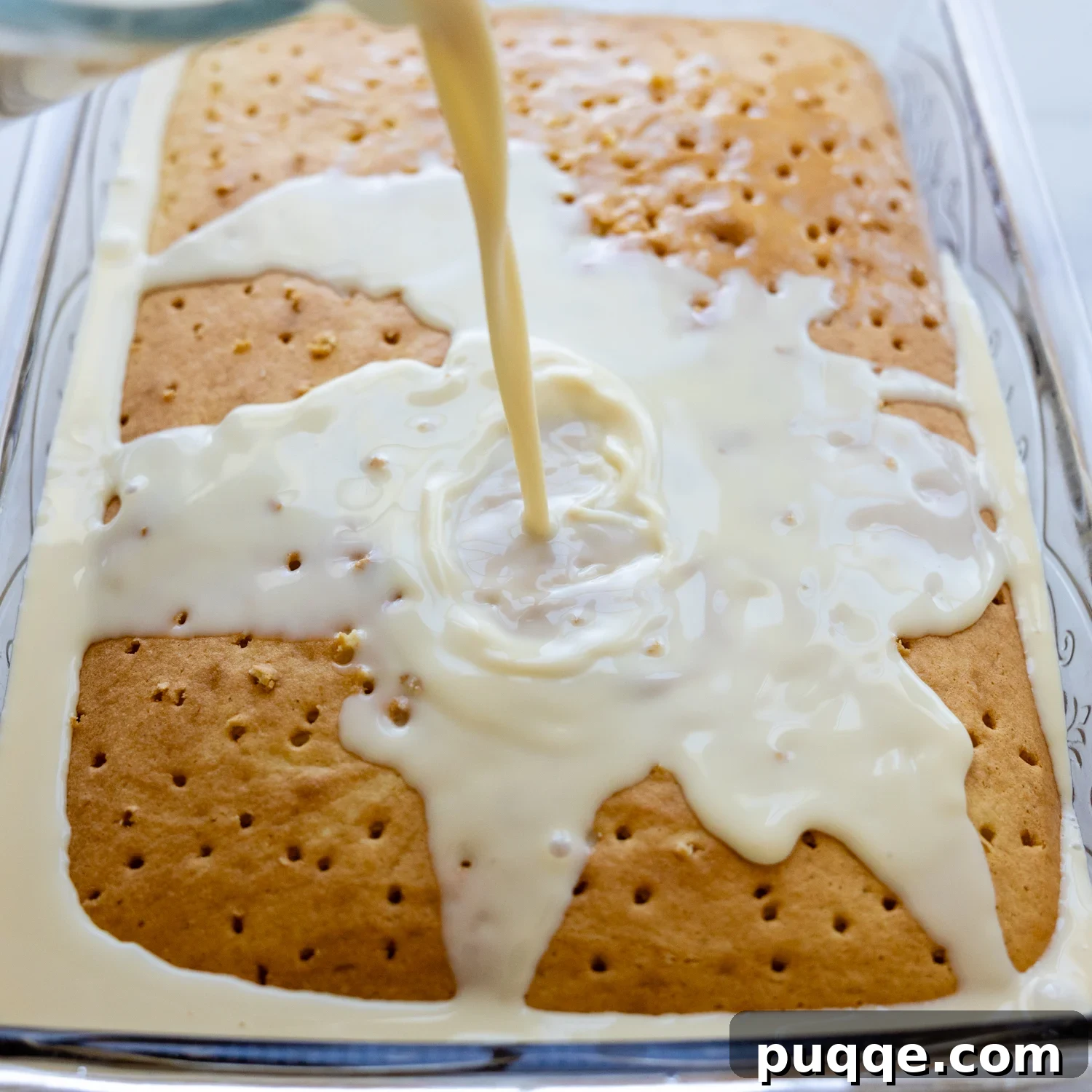 Absolutely Perfect Gluten-Free Tres Leches Cake 7 The baked cake, now with holes poked into it, as the three-milk soak is being slowly poured over the top.