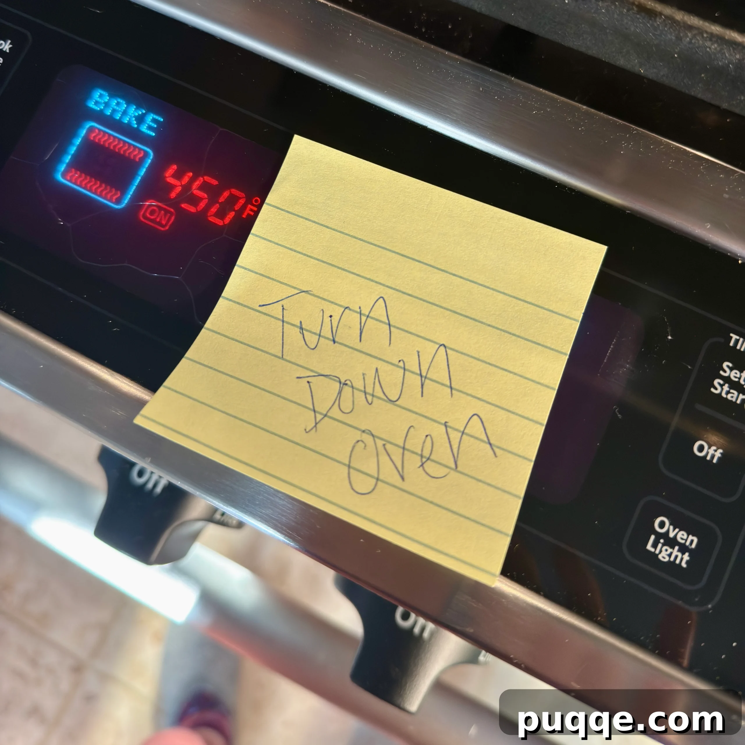 A sticky note on an oven reminding the baker to turn down the temperature, a practical tip to prevent burnt bread.