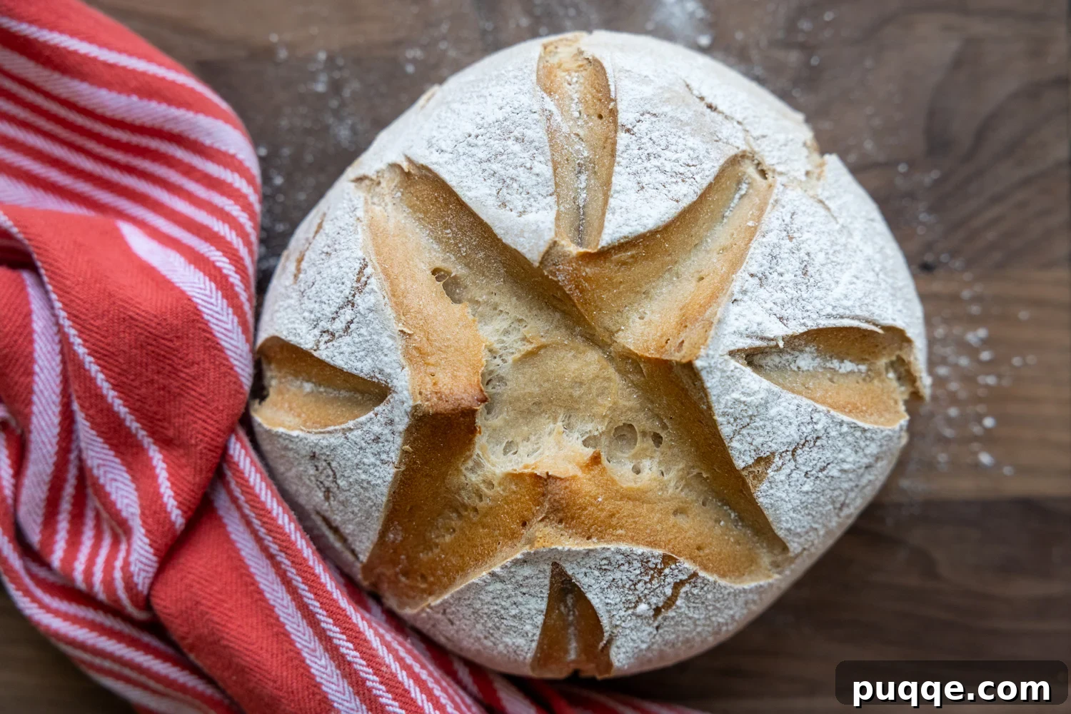 A freshly baked, golden-brown gluten-free sourdough loaf cooling on a wire rack.