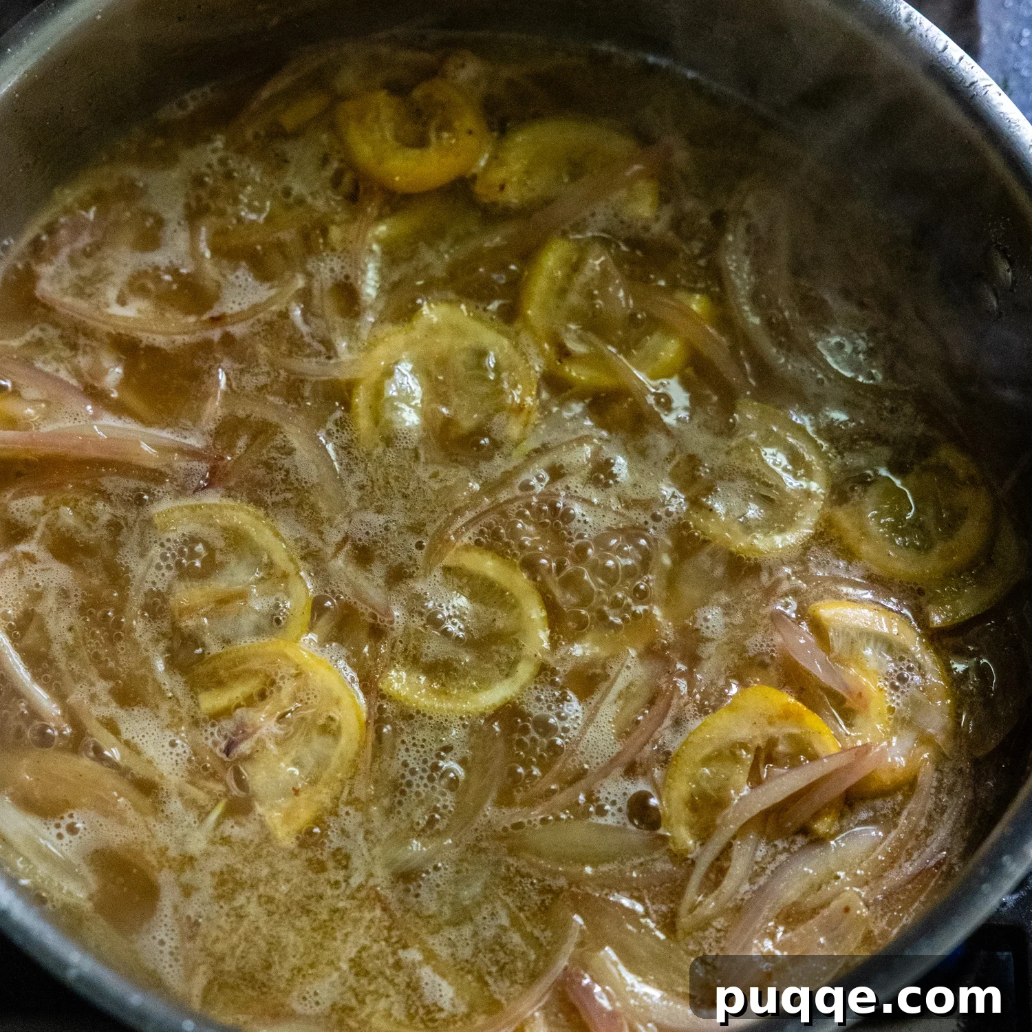 Wine added to stock pan with sautéed shallots and lemon slices.